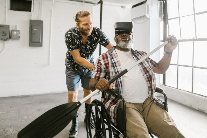 en äldre man i rullstol paddlar i en virtuell värld